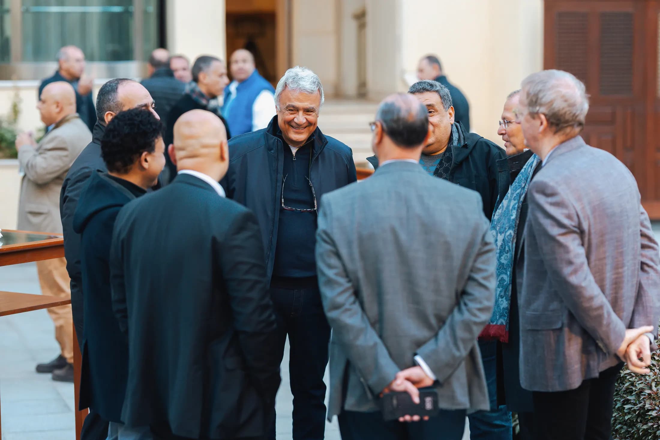 A circle of members in conversation outside the venue