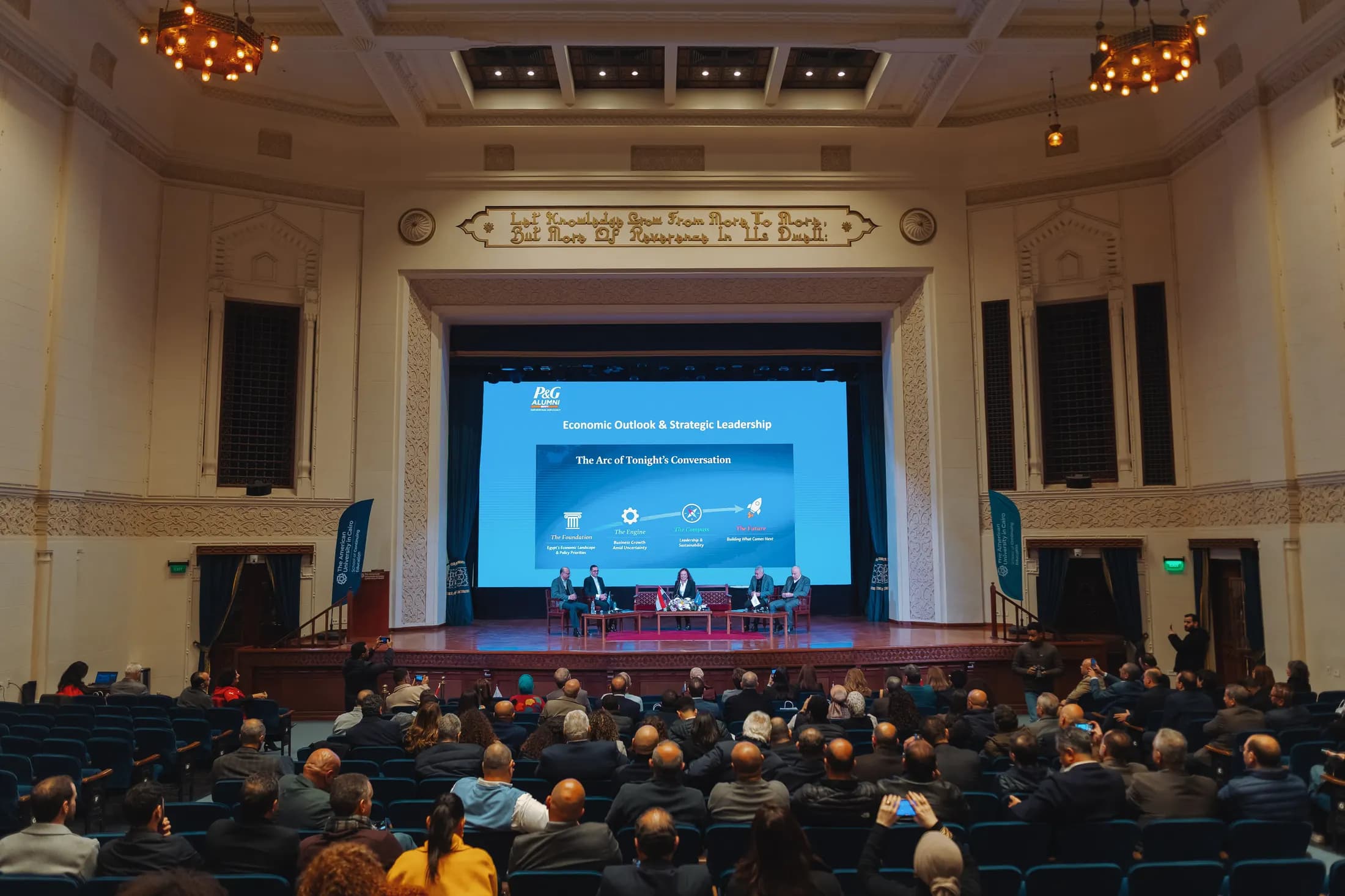 A panel discussion on stage in front of a full auditorium